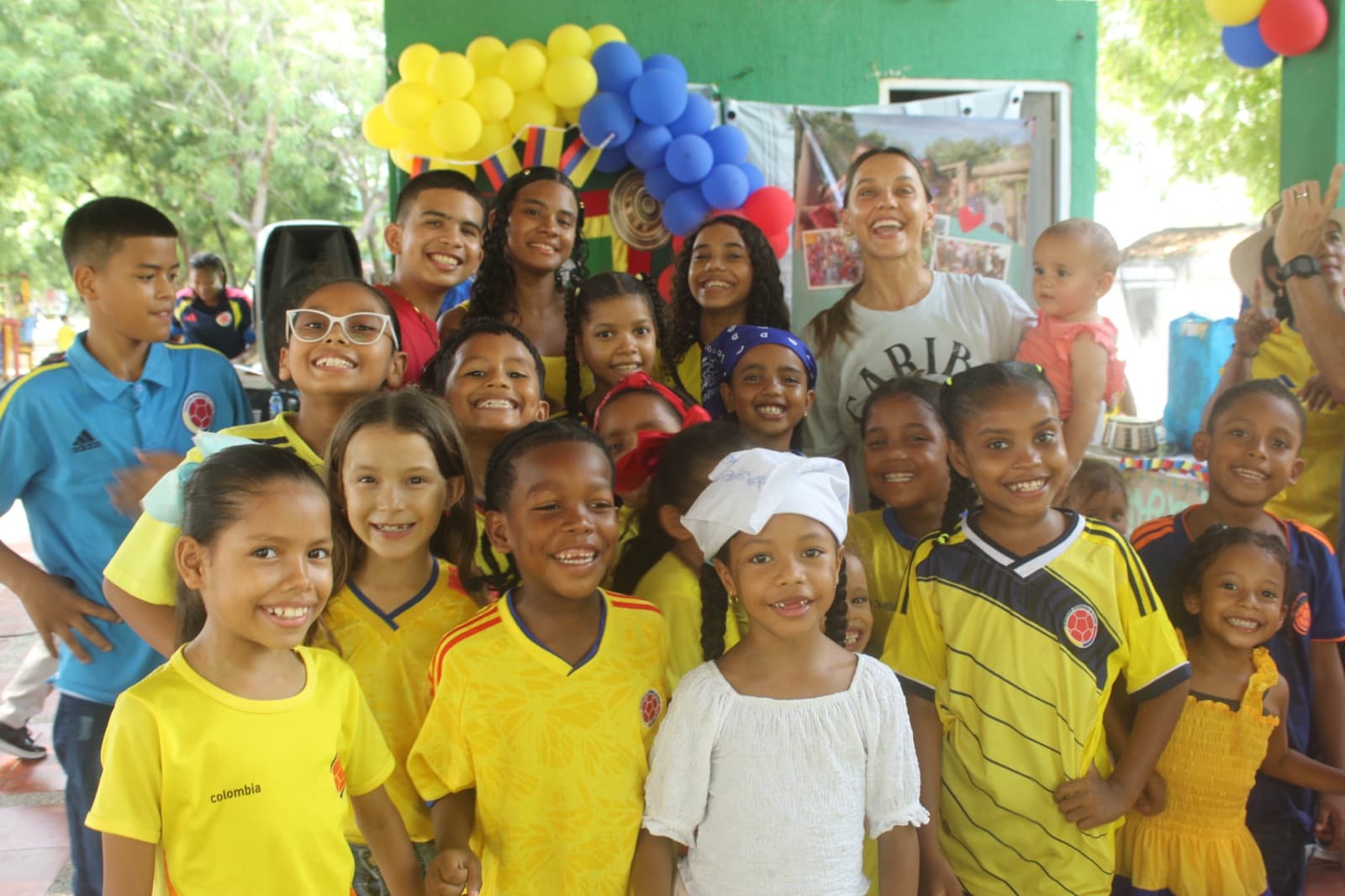 Students in yellow Colombia jerseys smiling together at the celebration