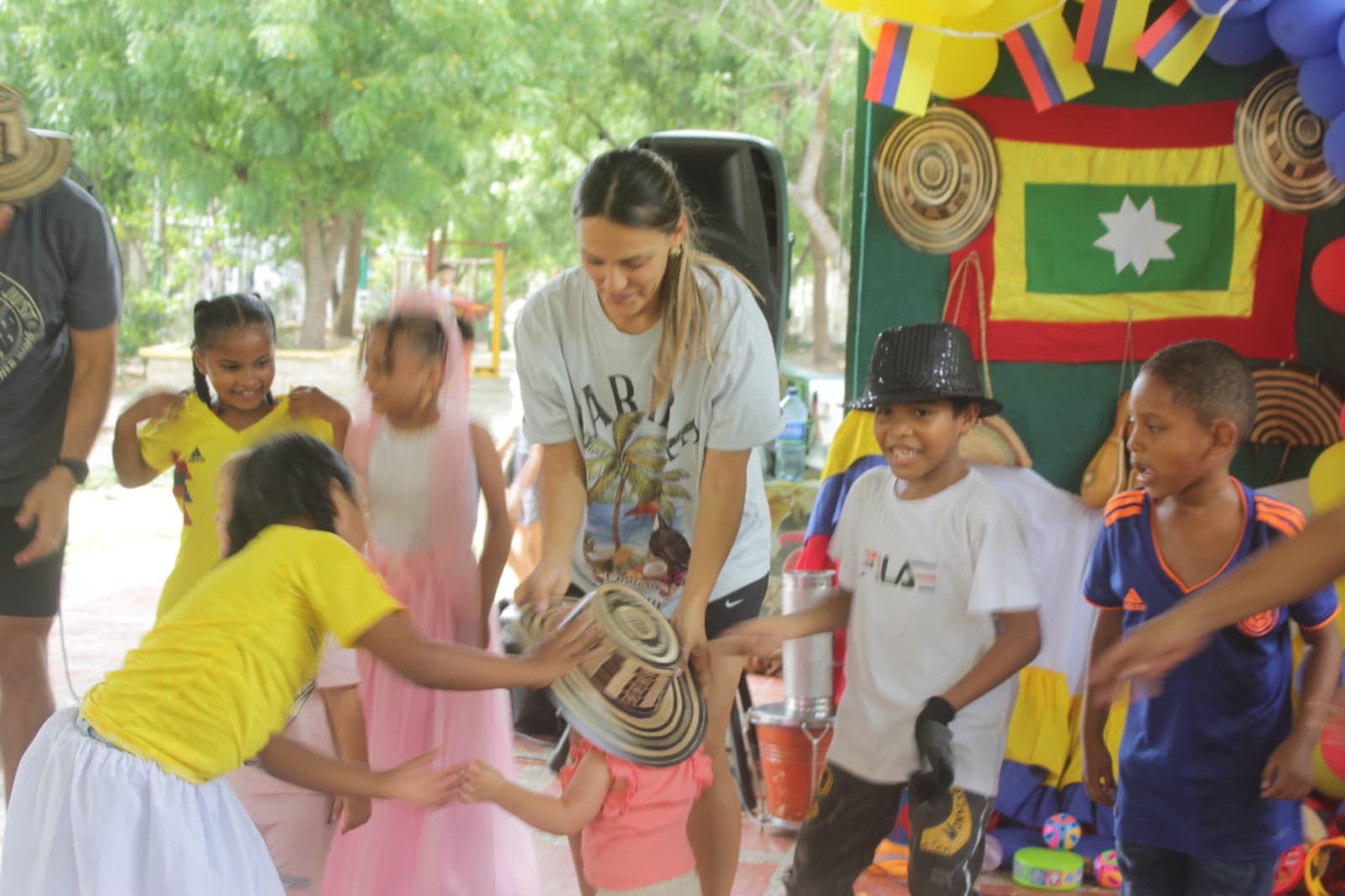 A volunteer handing out sombreros vueltiaos to the children