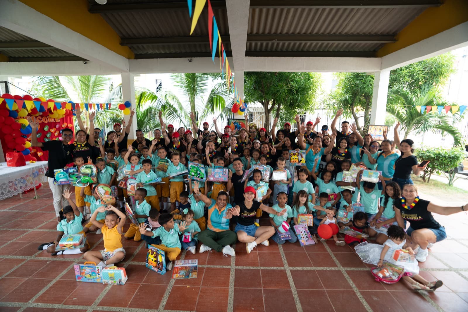 Un equipo corporativo y niños celebrando juntos en la Fundación Una Luz en Cartagena, Colombia
