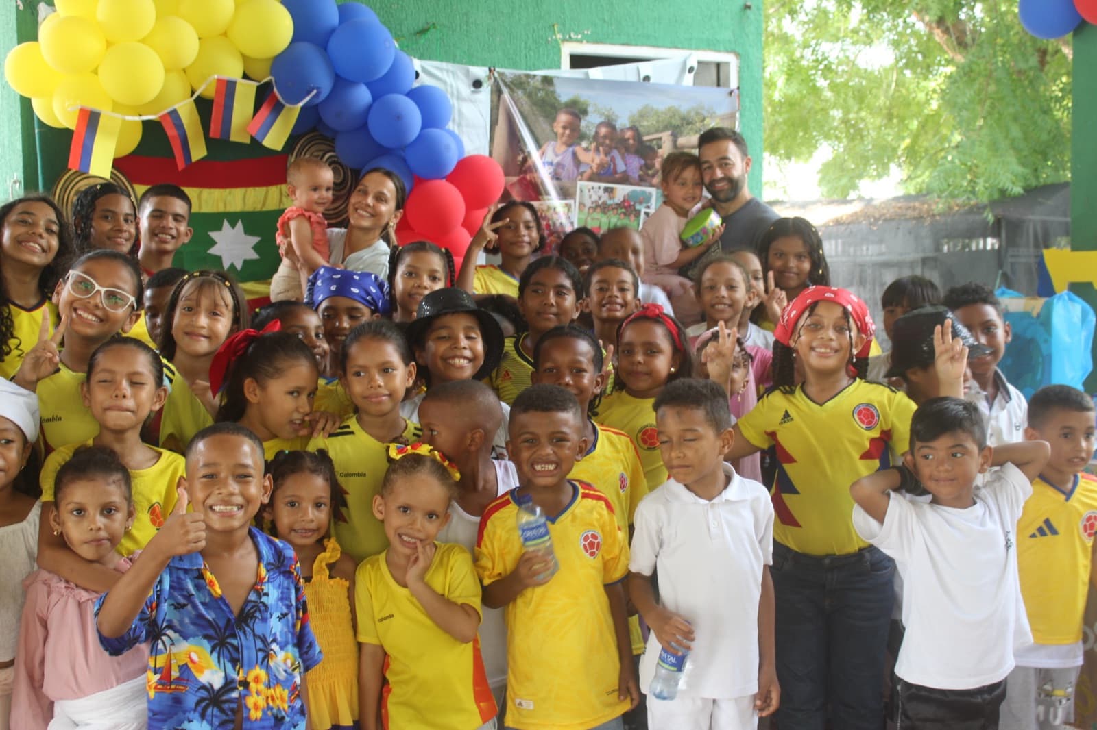 The whole school gathered under a yellow, blue and red balloon arch in Colombia jerseys at Una Luz Foundation in Cartagena
