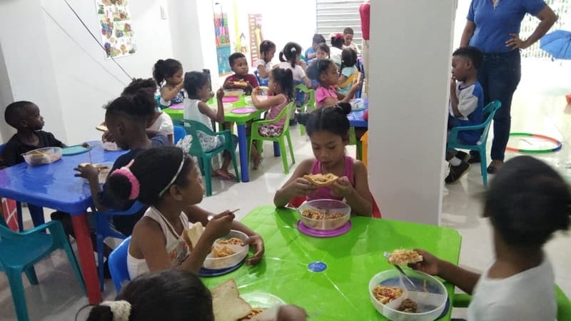 Niños comiendo juntos en la escuela de la Fundación Una Luz en Cartagena